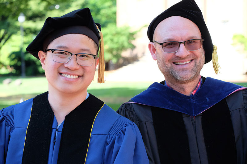Two doctoral hooding event attendees